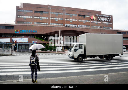 Thai Frau Holding Regenschirm während Regen und Kreuz über Straße am Zebrastreifen vor Kintetsu Nara Bahnhof am 7. Juli 2015 warten Stockfoto