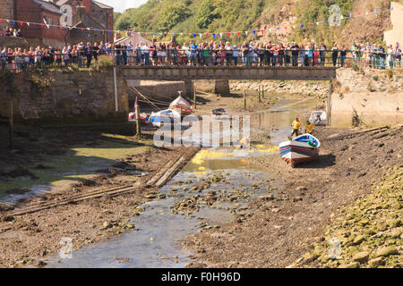 Staithes, UK. 15. August 2015. Massen an der Brücke über Roxby Beck Jubel auf die Enten während der jährlichen RNLI-Ente Rennen Staithes, Sonntag, 16. August 2015, die RNLI hält eine jährliche Wochenende von Veranstaltungen in der Fischerei Dorf Staithes an der Nordostküste Englands. Bildnachweis: Graham Hardy/Alamy Live-Nachrichten Stockfoto