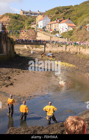 Staithes, UK. 15. August 2015. Drei Mitglieder der RNLI (Royal National Lifeboat Institute) warten auf der Ziellinie von der jährlichen Entenrennen Staithes, Sonntag, 16. August 2015.  Die RNLI hält eine jährliche Wochenende von Veranstaltungen in der Fischerei Dorf Staithes an der Nord-Osten Englands. Bildnachweis: Graham Hardy/Alamy Live-Nachrichten Stockfoto