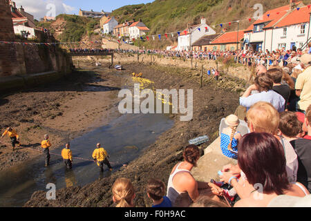 Staithes, UK. 15. August 2015. Massen warten auf der Ziellinie von der jährlichen RNLI (Royal National Lifeboat Institute) Entenrennen in der Fischerei Dorf Staithes auf der Nord-Ost Küste von England.Sunday 16. August 2015, UK Credit: Graham Hardy/Alamy Live News Stockfoto