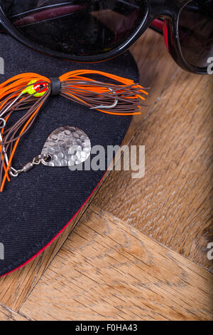 Closeup Angeln Köder mit schwarze Kappe und Sonnenbrille auf hölzernen Hintergrund locken Stockfoto