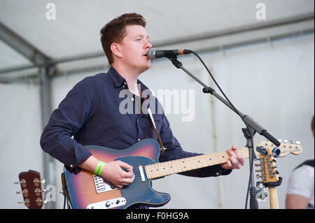 Crieff, Schottland, 16. August 2015. Die beliebte Folkband Skerryvore aus die Insel Tiree durchgeführt in Crieff Highland Games.das Band mischt verschiedene Musikstile um eine einmalige Leistung zu erstellen, die das Publikum genossen. Alec Norman Dalglish von Livingston spielt Gitarre und singt für die Band. Bildnachweis: Andrew Steven Graham/Alamy Live-Nachrichten Stockfoto