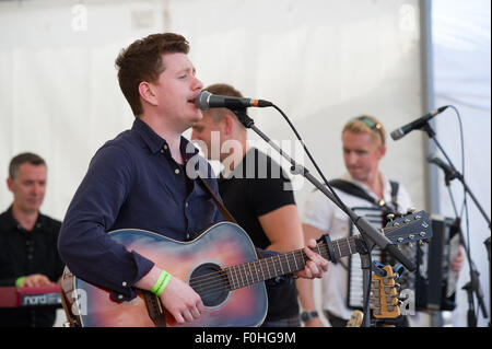 Crieff, Schottland, 16. August 2015. Die beliebte Folkband Skerryvore aus die Insel Tiree durchgeführt in Crieff Highland Games.das Band mischt verschiedene Musikstile um eine einmalige Leistung zu erstellen, die das Publikum genossen. Alec Norman Dalglish von Livingston spielt Gitarre und singt für die Band. Bildnachweis: Andrew Steven Graham/Alamy Live-Nachrichten Stockfoto