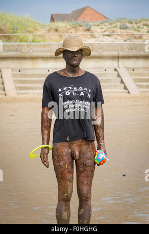 Antony Gormleys ein weiterer Ort Skulptur auf Crosby Strand trug ein T-shirt und Hut Stockfoto