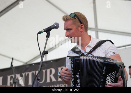 Crieff, Schottland, 16. August 2015. Die beliebte Folkband Skerryvore aus die Insel Tiree durchgeführt in Crieff Highland Games.das Band mischt verschiedene Musikstile um eine einmalige Leistung zu erstellen, die das Publikum genossen. Daniel Anthony Gillespie von Tiree auf der Ziehharmonika. Bildnachweis: Andrew Steven Graham/Alamy Live-Nachrichten Stockfoto