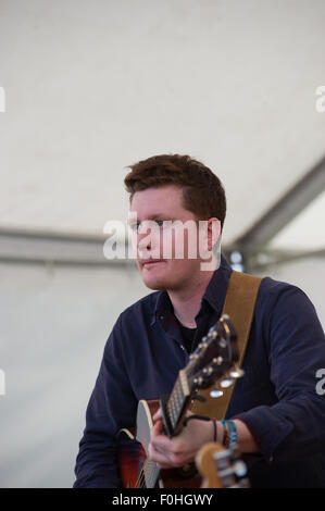 Crieff, Schottland, 16. August 2015. Die beliebte Folkband Skerryvore aus die Insel Tiree durchgeführt in Crieff Highland Games.das Band mischt verschiedene Musikstile um eine einmalige Leistung zu erstellen, die das Publikum genossen. Alec Norman Dalglish von Livingston spielt Gitarre und singt für die Band. Bildnachweis: Andrew Steven Graham/Alamy Live-Nachrichten Stockfoto