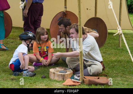 Anglo-Saxon und Viking-Reenactment-Mann tut eine Demonstration für Kleinkinder bei Cannock Chase Visitor Centre UK Stockfoto