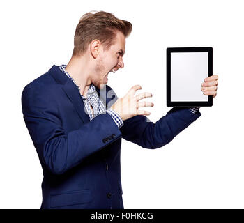 Studioaufnahme von ein zorniger junger Mann zeigt etwas auf eine digital-Tablette. Stockfoto
