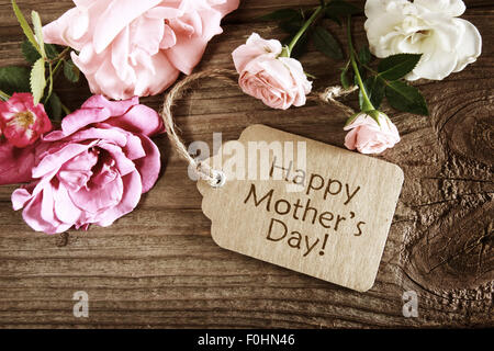 Mütter-Tageskarte mit rustikalen Rosen auf Holzbrett Stockfoto