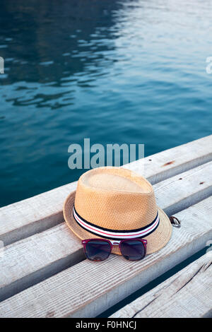 Sonnenbrillen, Flip-flops und Hut auf die hölzerne Struktur im Sommer. Stockfoto