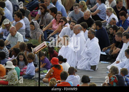 Taizé, Frankreich. 16. August 2015. Die Brüder von Taizé sitzen in der Mitte der Pilger. Die Brüder von Taizé, zusammen mit Tausenden von Pilgern und Führer der Kirche aus vielen verschiedenen Konfession, statt ein Gebet der Danksagung in Erinnerung von Frère Roger auf den 10. Jahrestag seines Todes und im Jahr seines 100. Geburtstages und den 75. Jahrestag seiner Ankunft in Taizé. Stockfoto