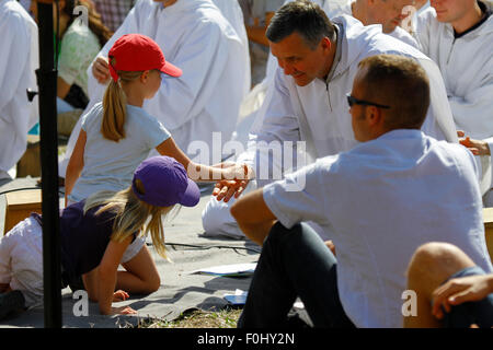 Burgund, Frankreich. 16. August 2015. Ein kleines Mädchen macht das Kreuzzeichen in die Handfläche einer der Brüder von Taizé. Die Brüder von Taizé, zusammen mit Tausenden von Pilgern und Führer der Kirche aus vielen verschiedenen Konfession, statt ein Gebet der Danksagung in Erinnerung von Frère Roger auf den 10. Jahrestag seines Todes und im Jahr seines 100. Geburtstages und den 75. Jahrestag seiner Ankunft in Taizé. © Michael Debets/Pacific Press/Alamy Live-Nachrichten Stockfoto