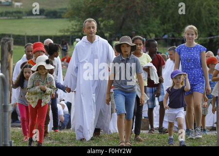 Burgund, Frankreich. 16. August 2015. Frère Alois, Prior der Communauté Taizé verlässt das Gebet, umringt von Kindern. Die Brüder von Taizé, zusammen mit Tausenden von Pilgern und Führer der Kirche aus vielen verschiedenen Konfession, statt ein Gebet der Danksagung in Erinnerung von Frère Roger auf den 10. Jahrestag seines Todes und im Jahr seines 100. Geburtstages und den 75. Jahrestag seiner Ankunft in Taizé. © Michael Debets/Pacific Press/Alamy Live-Nachrichten Stockfoto