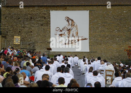 Burgund, Frankreich. 16. August 2015. Die Brüder von Taizé und die Pilger sitzen auf einem Feld vor einer Scheune, wo der Altar steht. Die Brüder von Taizé, zusammen mit Tausenden von Pilgern und Führer der Kirche aus vielen verschiedenen Konfession, statt ein Gebet der Danksagung in Erinnerung von Frère Roger auf den 10. Jahrestag seines Todes und im Jahr seines 100. Geburtstages und den 75. Jahrestag seiner Ankunft in Taizé. © Michael Debets/Pacific Press/Alamy Live-Nachrichten Stockfoto