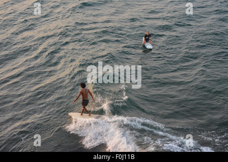 Eine Surfer reitet die Wellen am Batukaras, West-Java im August 2015. Stockfoto