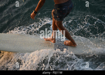 Eine Surfer reitet die Wellen am Batukaras, West-Java im August 2015. Stockfoto