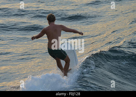 Eine Surfer reitet die Wellen am Batukaras, West-Java im August 2015. Stockfoto