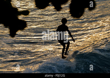 Eine Surfer reitet die Wellen am Batukaras, West-Java im August 2015. Stockfoto