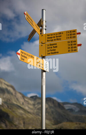 Verkehrszeichen in den Bergen des Kantons Wallis, verschiedene Zeichen mit Richtungen und Entfernungen zwischen berühmten Sehenswürdigkeiten Stockfoto