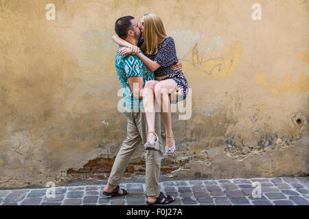 Glückliches junges Paar in Liebe Spaß gegen die Wand des Hauses. Stockfoto