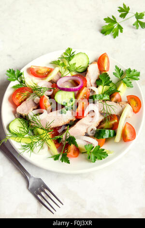 Bunter Gemüsesalat mit Fleisch (gebratenes Schweinefleisch) auf weißen Teller und rustikalen Tisch Draufsicht Stockfoto