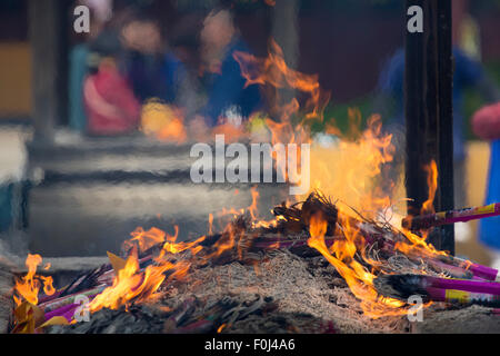 Gebete, die brennende Räucherstäbchen bei Feuer im Jade Tempel in Shanghai, China Stockfoto