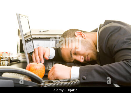 Business-Mann schlafen bei der Arbeit mit Kopf auf seinem laptop Stockfoto