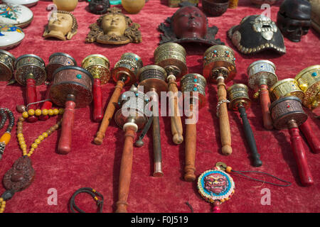 Buddhistische Gebetsmühlen zu verkaufen, die Festlegung auf einen roten Tisch in einem Markt, Tibet, China 2013. Stockfoto