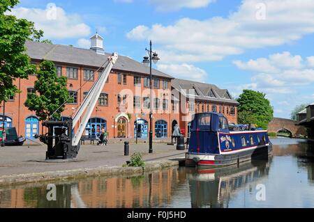 Narrowboat vertäut in der Kanal-Becken mit einer Industriekran, Coventry, England. Stockfoto