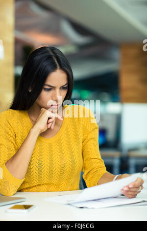 Porträt einer schönen Geschäftsfrau, Lesen von Dokumenten im Büro Stockfoto