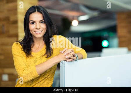 Porträt von glücklich schöne Geschäftsfrau im Büro stehen und Blick in die Kamera Stockfoto