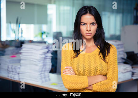 Porträt von wütenden Geschäftsfrau mit im Büro verschränkten Armen stehend Stockfoto