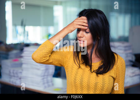 Porträt von lässig Geschäftsfrau mit Kopfschmerzen in Büro Stockfoto
