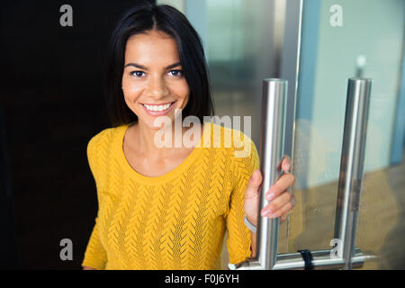 Porträt von lächelnden niedlich Geschäftsfrau im Büro stehen und Blick in die Kamera Stockfoto