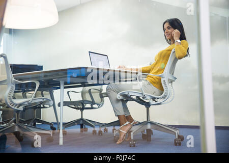 Porträt von glücklich Geschäftsfrau sitzen ein Tisch und am Telefon im Büro Stockfoto