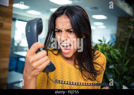 Wütend Geschäftsfrau schreien am Telefon im Büro Stockfoto