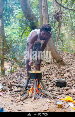 Mann von den Orang Asil Kochen auf dem Feuer im tropischen Dschungel Regen Wald, Taman Negara Malaysia Stockfoto