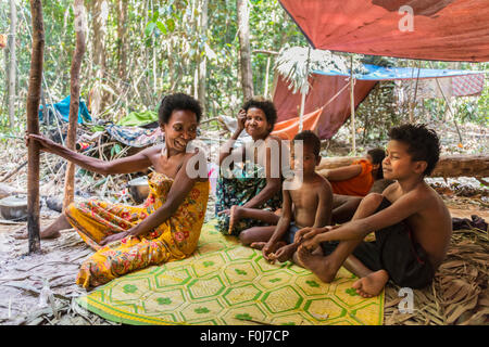 Frauen und Kinder des Stammes Orang Asil sitzen unter Planen im Dschungel, native, indigene Völker Stockfoto