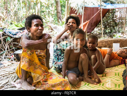 Frauen und Kinder des Stammes Orang Asil sitzen unter Planen im Dschungel, native, indigene Völker Stockfoto