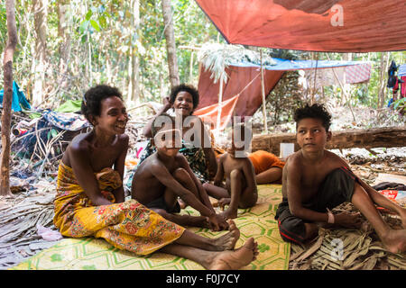 Frauen und Kinder des Stammes Orang Asil sitzen unter Planen im Dschungel, native, indigene Völker Stockfoto