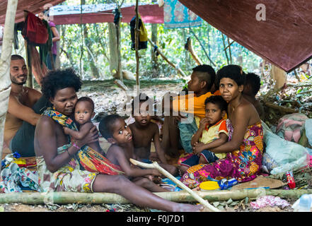 Männer, Frauen und Kinder des Stammes Orang Asil sitzen unter Planen im Dschungel, native, indigene Völker Stockfoto