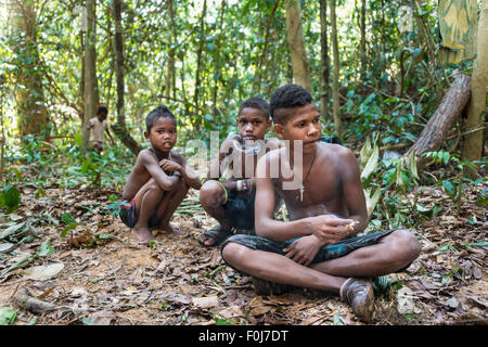 Drei jungen des Stammes Orang Asil sitzen auf dem Boden in den Dschungel und Rauchen, indigenen Menschen, tropischer Regenwald Stockfoto