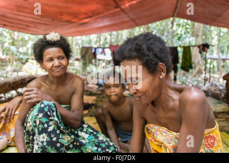 Frauen und Kinder des Stammes Orang Asil sitzen unter Planen im Dschungel, native, indigene Völker Stockfoto