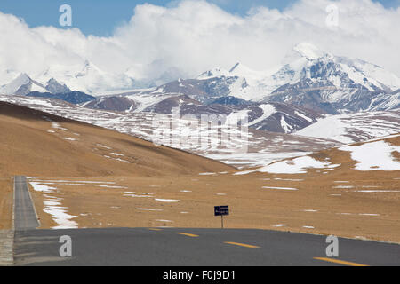 Gerade Straße mit einer gelben gepunkteten Linie in der Mitte mit tibetischen Landschaft der Berge im Hintergrund. Friendship Highway Stockfoto