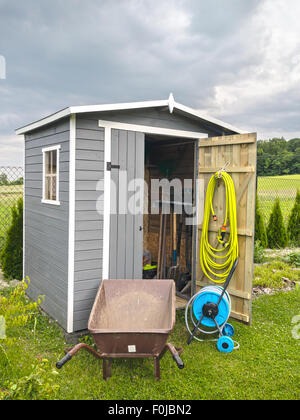 Hölzerne Schuppen mit verschiedenen Gartenwerkzeuge und Ausrüstung Stockfoto