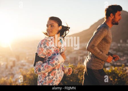 Junge Frau beim laufen mit einem Mann im Freien im Rückblick. Paar auf Morgenlauf. Stockfoto