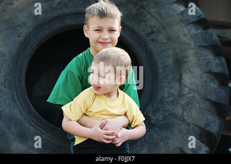 Kinder spielen im Schrottplatz Reifen Stockfoto