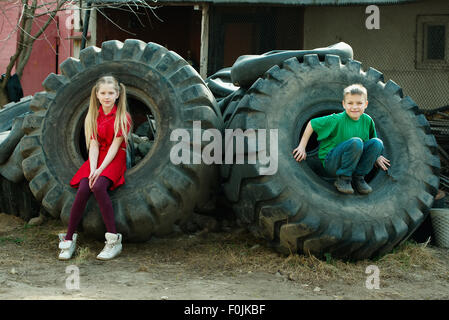 Kinder spielen im Schrottplatz Reifen Stockfoto