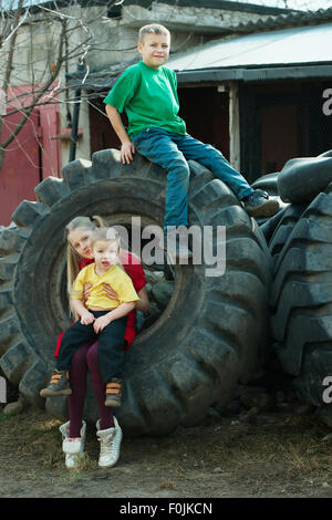 Kinder spielen im Schrottplatz Reifen Stockfoto