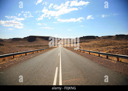 Auf dem Weg nach Keetmanshoop in Namibia. Breit, eine heiße und leer geteerte Straße durch trockenen Landschaften, ein Traum in Namibia zu fahren. Stockfoto